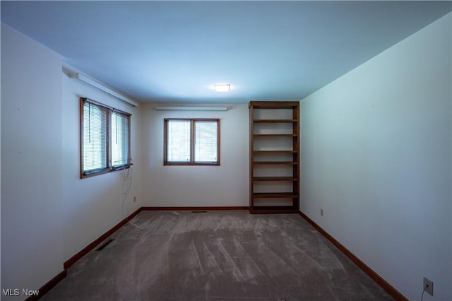 carpeted spare room featuring baseboards