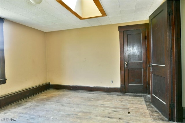 empty room featuring wood finished floors and baseboards