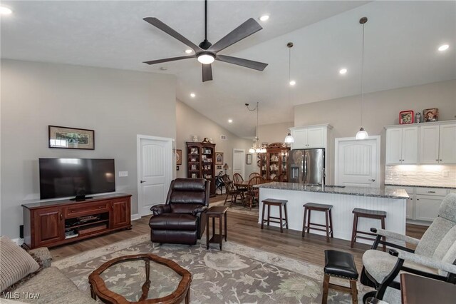 living room with light wood-style floors, high vaulted ceiling, ceiling fan, and recessed lighting