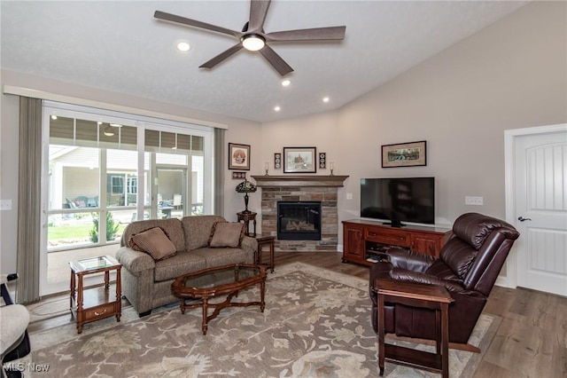 living room featuring wood finished floors, ceiling fan, vaulted ceiling, a fireplace, and recessed lighting