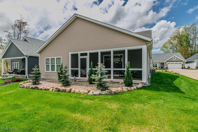 back of house with a yard, a sunroom, and a shingled roof