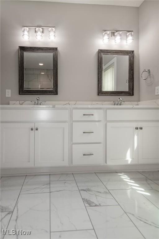 full bath with marble finish flooring and double vanity