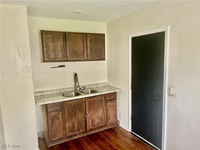 kitchen with a sink, dark wood-type flooring, and light countertops