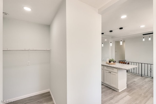 interior space with light wood finished floors, recessed lighting, baseboards, and pendant lighting