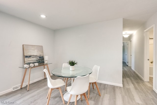 dining area featuring light wood finished floors, baseboards, and recessed lighting