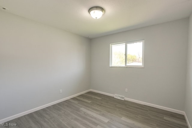 spare room featuring wood finished floors and baseboards