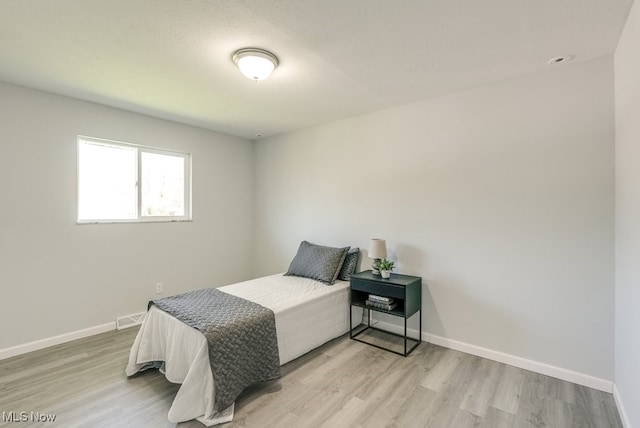 bedroom with light wood-style flooring and baseboards