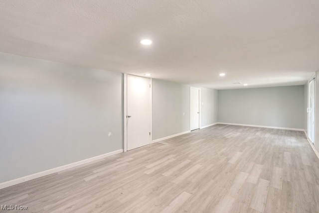 finished basement with recessed lighting, light wood-style flooring, and baseboards