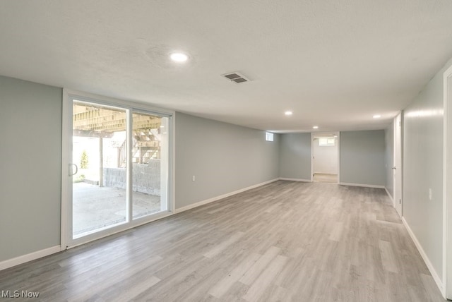 below grade area with light wood finished floors, recessed lighting, and baseboards