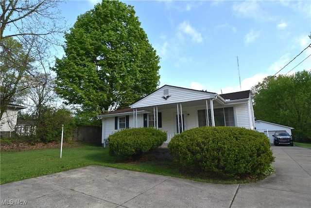bungalow featuring a front yard, a detached garage, and a porch