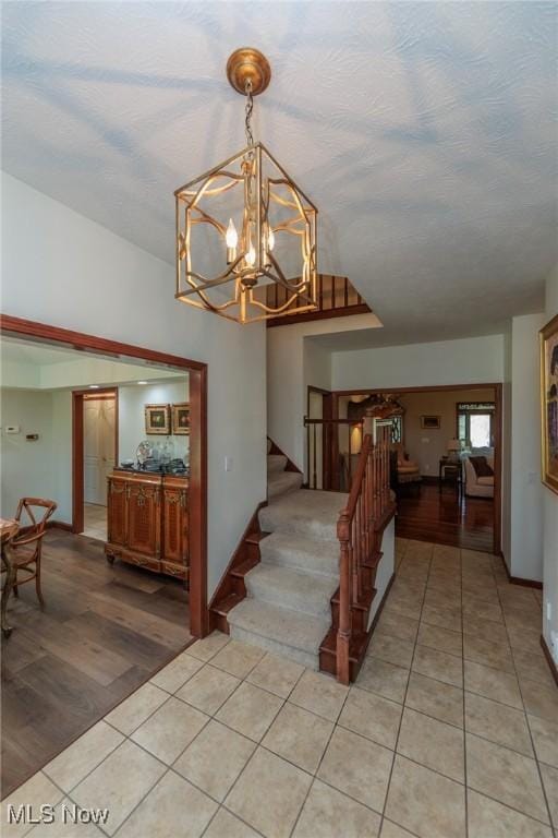 3286 Marks Rd, Medina, OH 44256 - stairway with tile patterned floors, a chandelier, and baseboards
