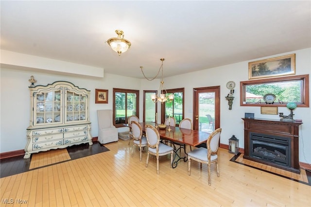 3286 Marks Rd, Medina, OH 44256 - dining area featuring a chandelier, light wood-type flooring, baseboards, and a glass covered fireplace