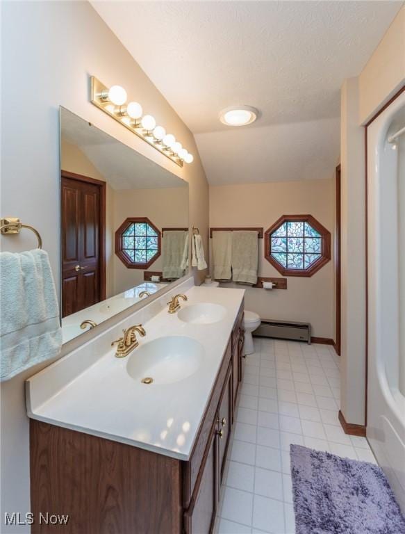 3286 Marks Rd, Medina, OH 44256 - bathroom featuring a baseboard heating unit, plenty of natural light, double vanity, tile patterned flooring, and lofted ceiling