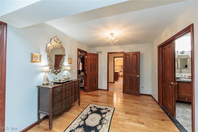 3286 Marks Rd, Medina, OH 44256 - hall featuring a chandelier, light wood-style floors, a sink, and baseboards