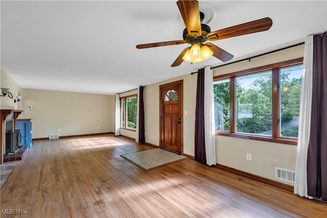 unfurnished living room featuring wood finished floors, a ceiling fan, and baseboards