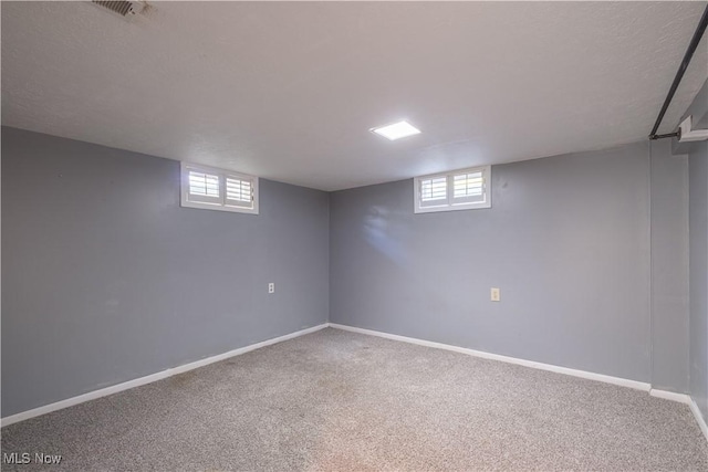 basement featuring plenty of natural light, carpet flooring, and baseboards