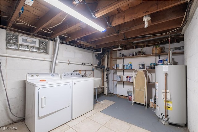 clothes washing area featuring gas water heater, separate washer and dryer, and concrete block wall