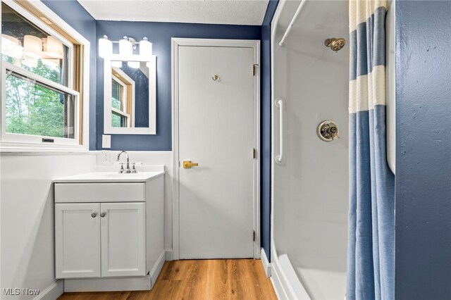full bath featuring wood finished floors, vanity, and a shower with shower curtain