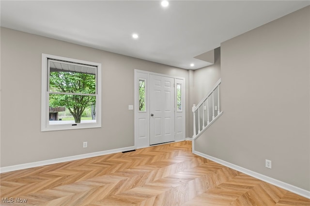 foyer entrance with stairs, recessed lighting, and baseboards