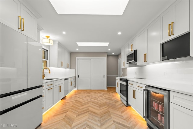 kitchen featuring beverage cooler, a skylight, decorative backsplash, recessed lighting, and light countertops