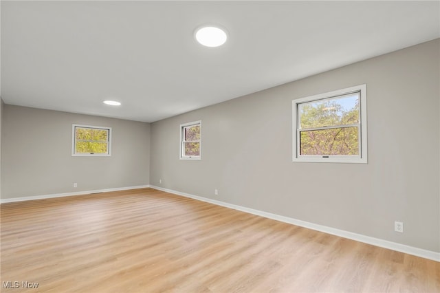 empty room with baseboards, light wood-style floors, and plenty of natural light