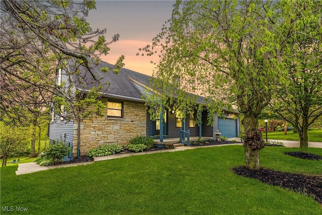 view of front of property featuring stone siding, covered porch, and a front yard