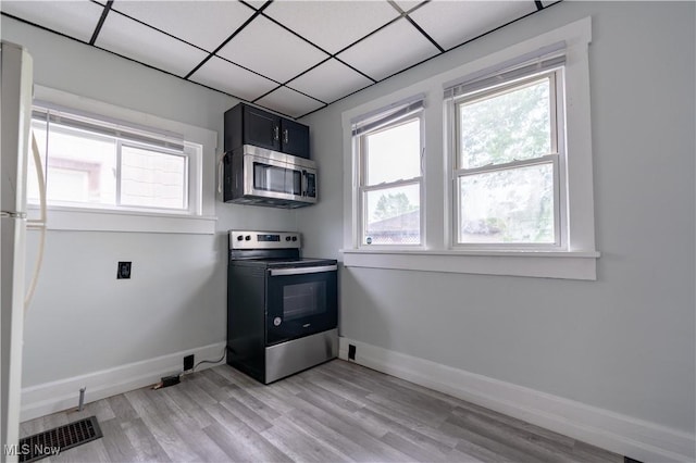 washroom with healthy amount of natural light, light wood finished floors, and baseboards