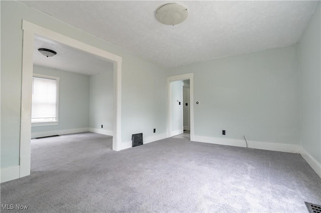 unfurnished room featuring carpet floors, baseboards, and a textured ceiling