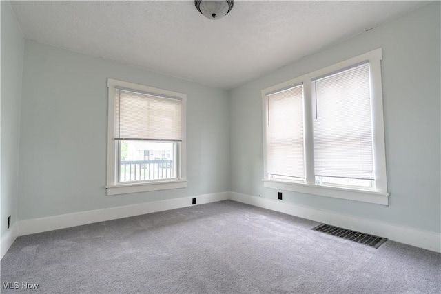 carpeted empty room with baseboards