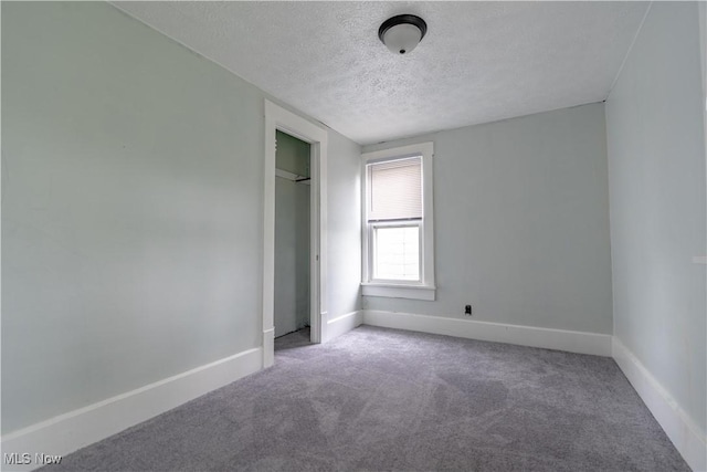 unfurnished bedroom featuring a textured ceiling, carpet floors, baseboards, and a closet