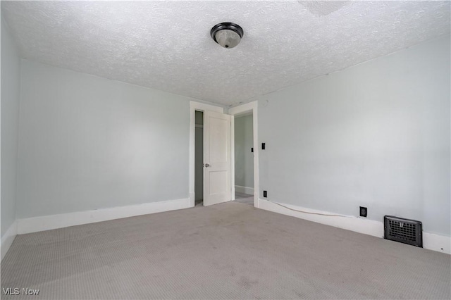 empty room with carpet flooring and a textured ceiling