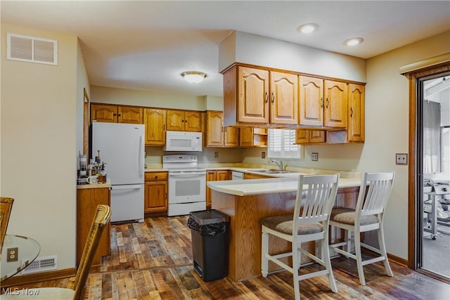312 58th St, Vienna, WV 26105 - kitchen with white appliances, a peninsula, light countertops, and dark wood-style flooring