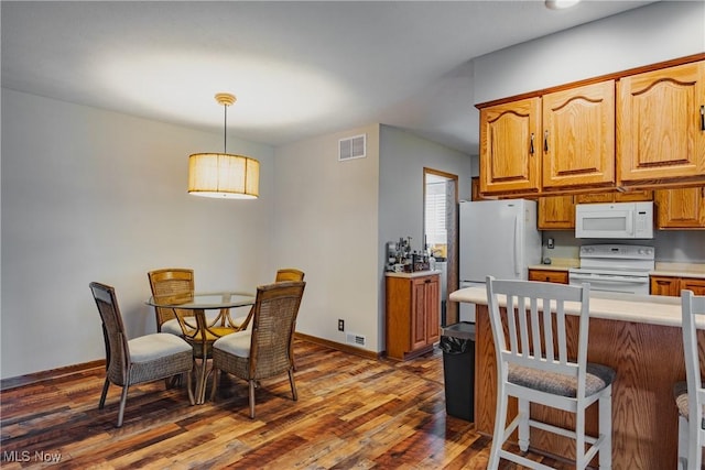 312 58th St, Vienna, WV 26105 - kitchen featuring white appliances, wood finished floors, light countertops, decorative light fixtures, and brown cabinets