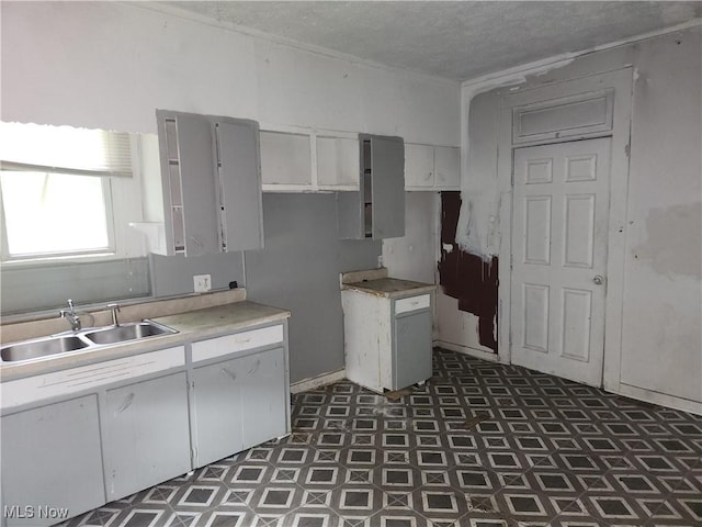 1010 S Liberty Ave, Alliance, OH 44601 - kitchen featuring tile patterned floors, a sink, white cabinets, light countertops, and a textured ceiling