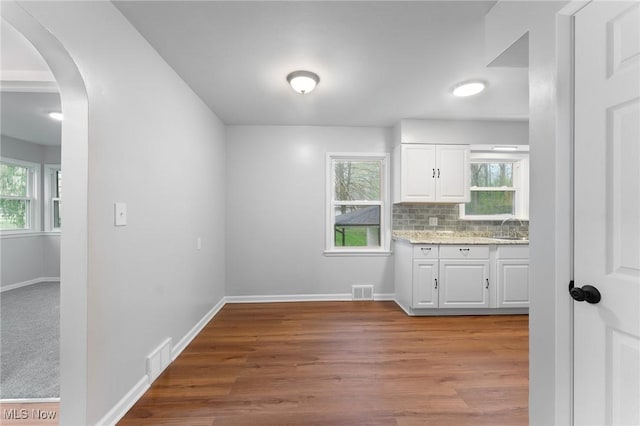283 Maple St, Newton Falls, OH 44444 - kitchen with arched walkways, white cabinetry, wood finished floors, and baseboards