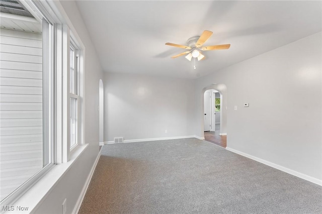 283 Maple St, Newton Falls, OH 44444 - carpeted empty room with arched walkways, ceiling fan, and baseboards