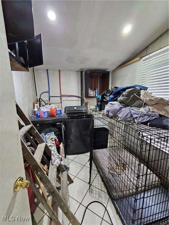 bedroom featuring washer / clothes dryer and light tile patterned flooring