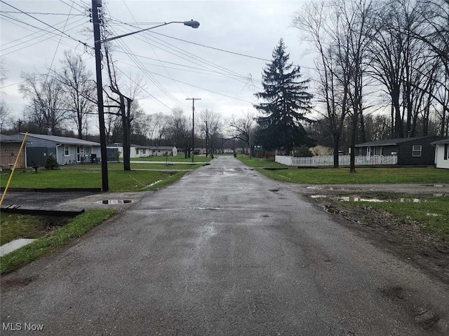 view of asphalt road with street lights and a residential view
