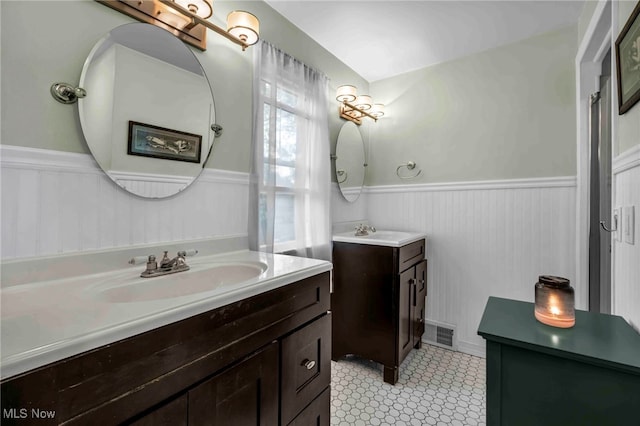 2508 Ashurst Rd, University Heights, OH 44118 - bathroom featuring wainscoting, two vanities, and tile patterned floors