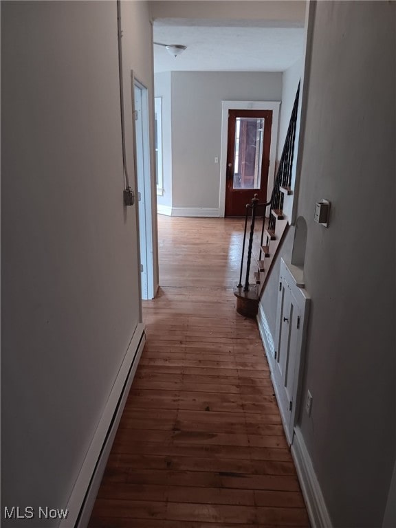 hallway with hardwood / wood-style flooring, stairway, baseboards, and baseboard heating