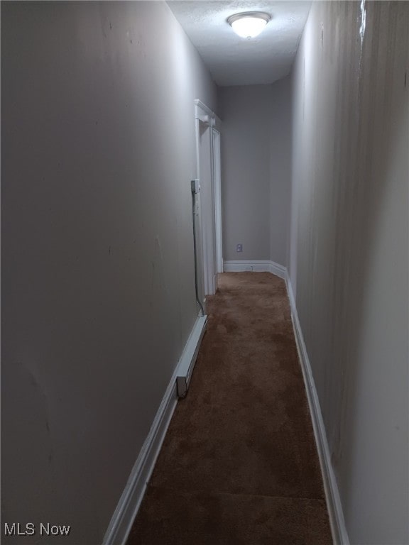 hall featuring carpet flooring and baseboards