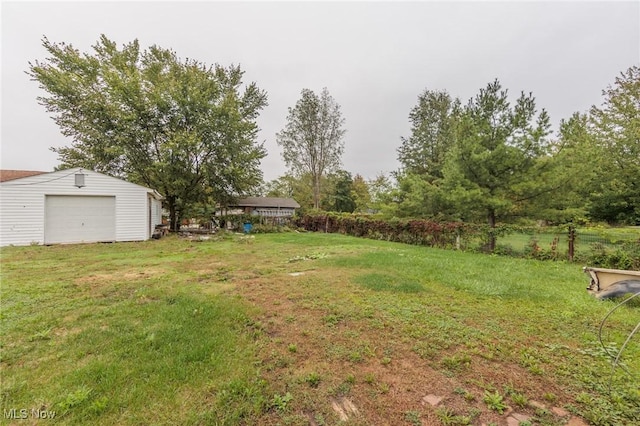 view of green lawn featuring an outbuilding and a garage
