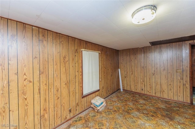 spare room with wood walls