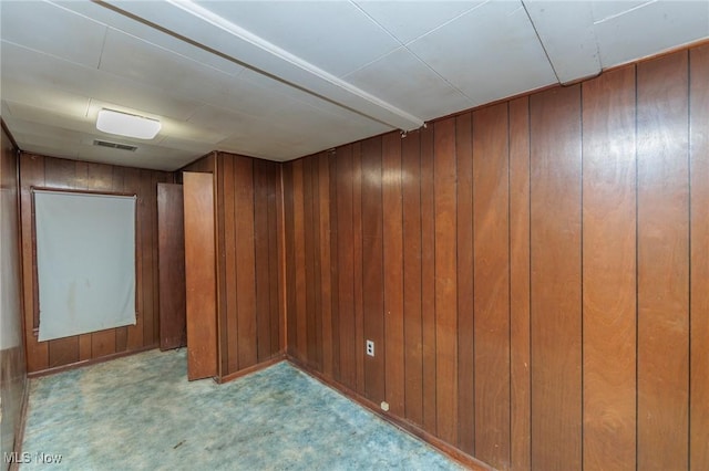 below grade area featuring wooden walls and carpet flooring