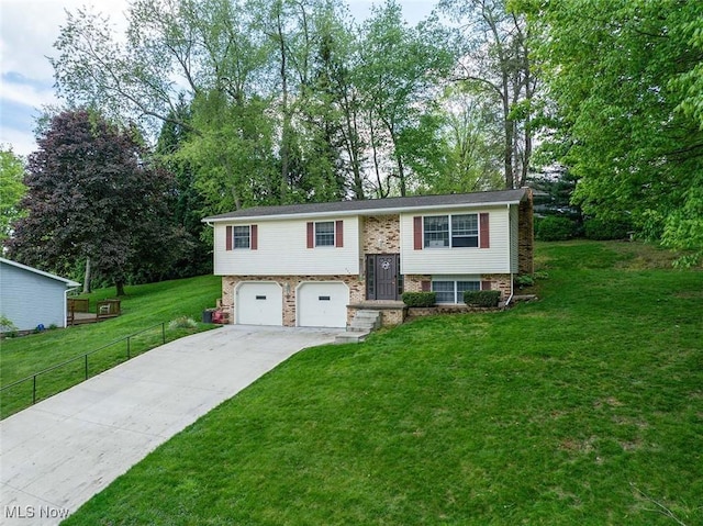 split foyer home featuring driveway, an attached garage, and view of wooded area