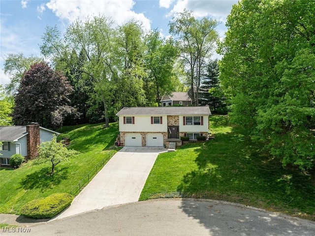 split foyer home with an attached garage, driveway, and a front yard