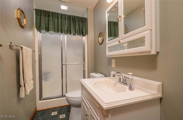 full bathroom featuring toilet, a stall shower, vanity, and baseboards