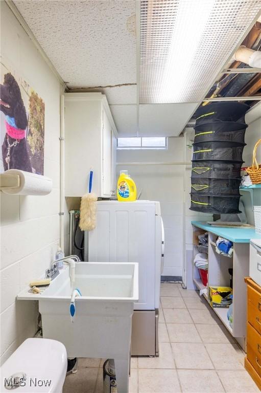 clothes washing area featuring light tile patterned floors and washer / clothes dryer