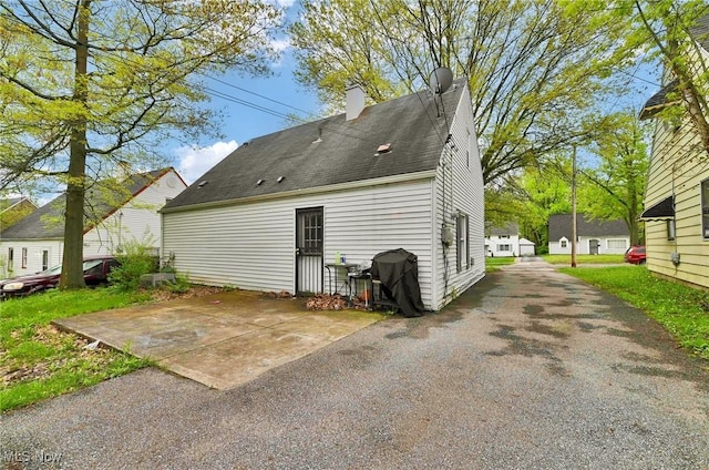19519 Meadowlark Ln, Warrensville Heights, OH 44128 - back of property featuring a chimney, a patio, and roof with shingles
