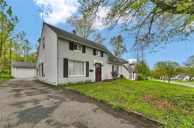19519 Meadowlark Ln, Warrensville Heights, OH 44128 - view of front of home featuring an outdoor structure, a chimney, a front lawn, and asphalt driveway